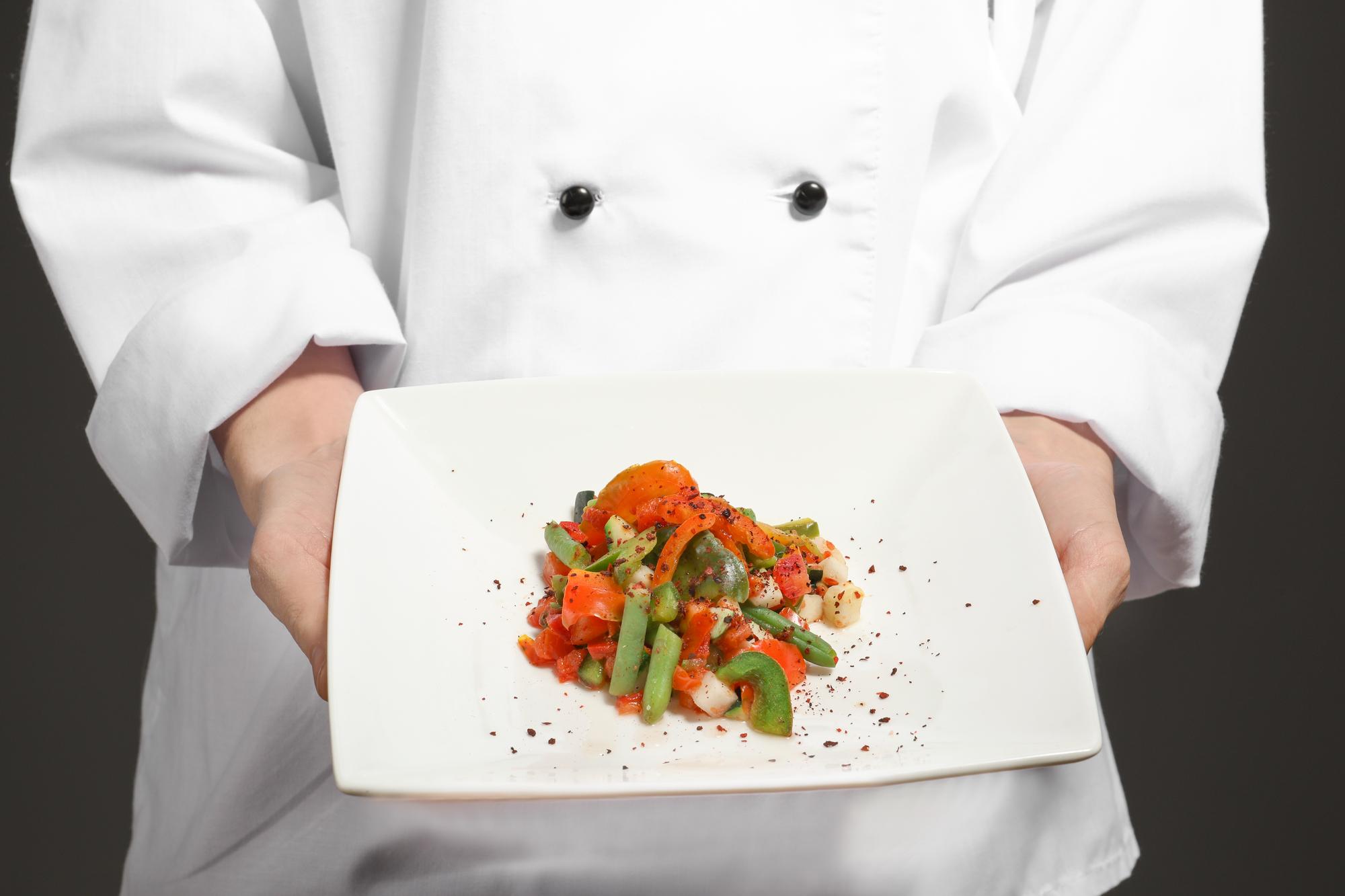 Chef che mostra un piatto colorato